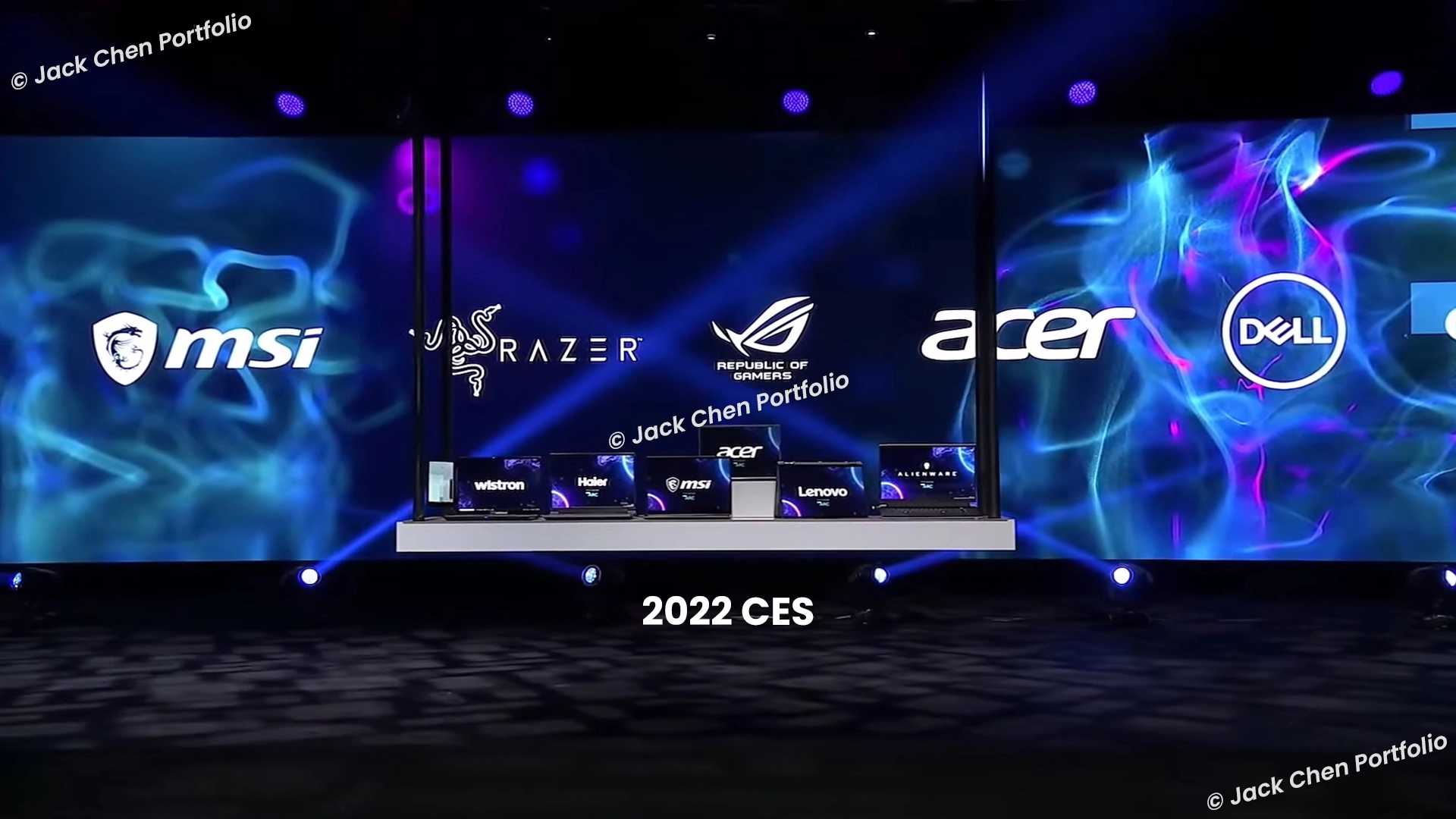2022 CES 展場舞台上，多個國際品牌筆電排成一列，左側一台螢幕顯示 Wistron 字樣的雙螢幕概念筆電，與 MSI、Razer、ROG、Acer、Dell 等品牌並列展示